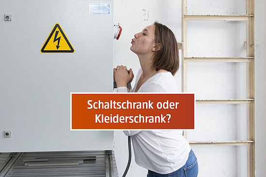 Motiv: Elena lehnt mit gespitzten Kusslippen an einem Schaltschrank. Frage: „Schaltschrank oder Kleiderschrank?“