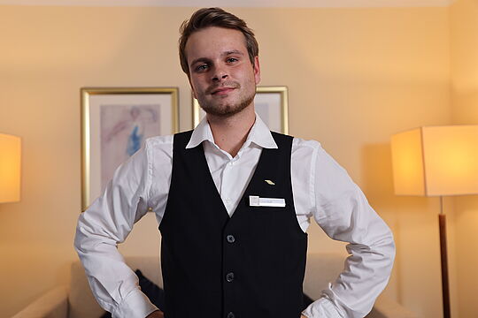 Lucas steht in einem Hotelzimmer.