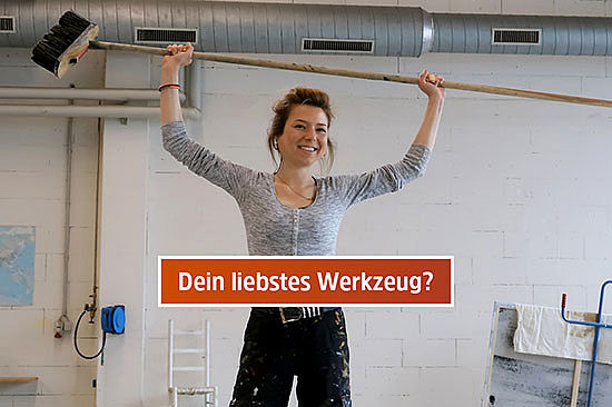 Textfeld mit Frage: „Dein liebstes Werkzeug?“ Amelie hebt eine Bürste mit gut zwei Meter langem Stiel hoch.