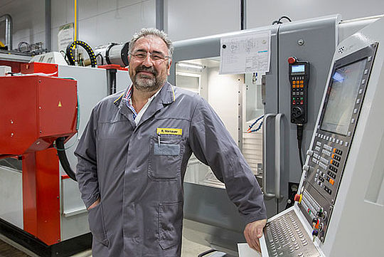 Rudolf Hornauer vor einem Bedienelement für eine Maschine im Hintergrund.
