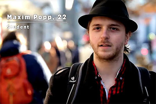 Ein junger Mann mit schwarzem Hut, Schriftzug links oben: Maxim Popp, 22, Student