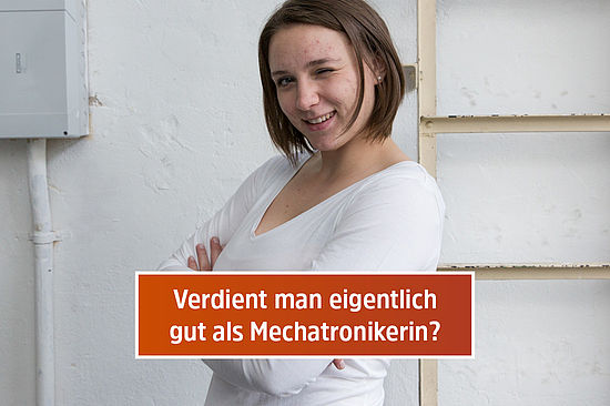 Motiv: Elena verschränkt die Arme und zwinkert. Frage: „Verdient man eigentlich gut als Mechatronikerin?“
