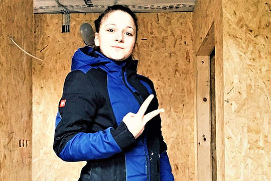 Anlagenmechanikerin Pia zeigt zwei Finger nach oben.