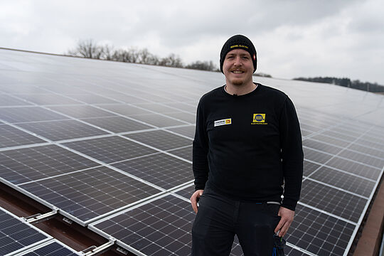 Thomas steht vor Solarzellen.
