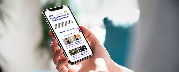 Ein Smartphone in einer Hand, das den Veranstaltungskalender zeigt.