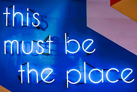 Leuchtende Schrift auf blauem Hintergrund.