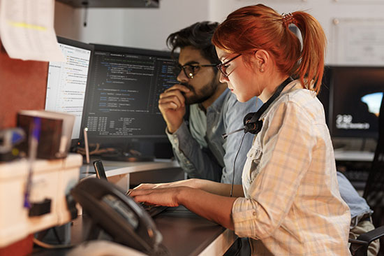 Junge Frau und junger Mann arbeiten am Computer. 