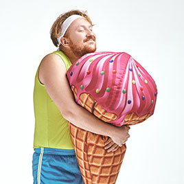 Ein Mann in Sportbekleidung umarmt eine menschengroße Eistüte.